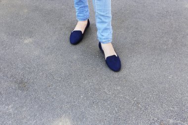 Kadın ayakları üzerinde gri arka plan asfalt