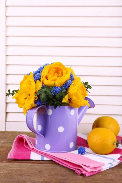 Composição com flores frescas da mola na lata da água no fundo de madeira — Fotografia de Stock