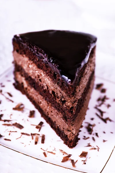 Pedaço de bolo de chocolate no prato branco, close-up — Fotografia de Stock