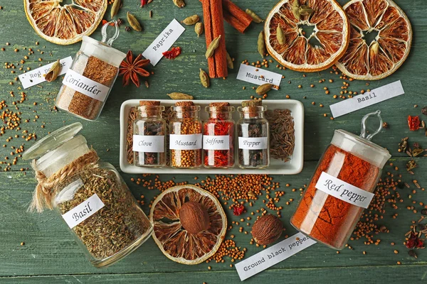 Assortment of spices in glass bottles on wooden background — Stock Photo, Image