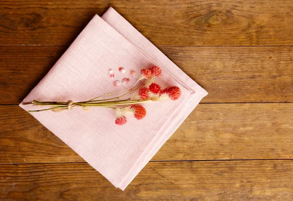 Beautiful dry flowers on napkin on wooden background — Stock Photo, Image