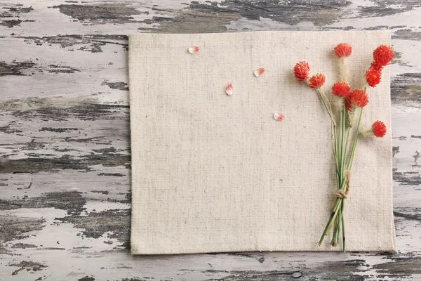 Beautiful dry flowers on napkin on wooden background — Stock Photo, Image