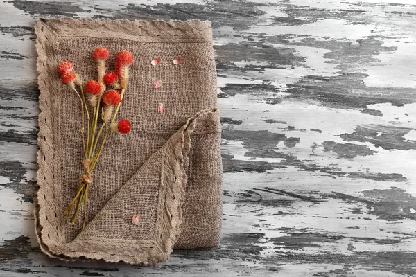 Beautiful dry flowers on napkin on wooden background — Stock Photo, Image