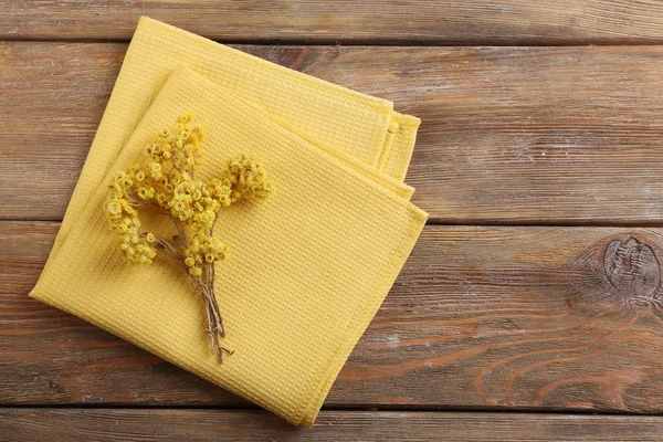 Hermosas flores secas en servilleta sobre fondo de madera —  Fotos de Stock