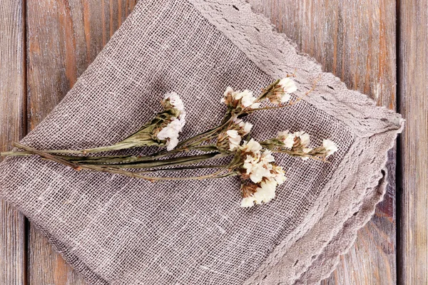 Beautiful dry flowers on napkin on wooden table close up — Stock Photo, Image