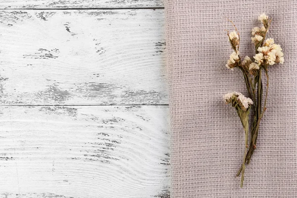 木製の背景にナプキンに美しいドライフラワー — ストック写真