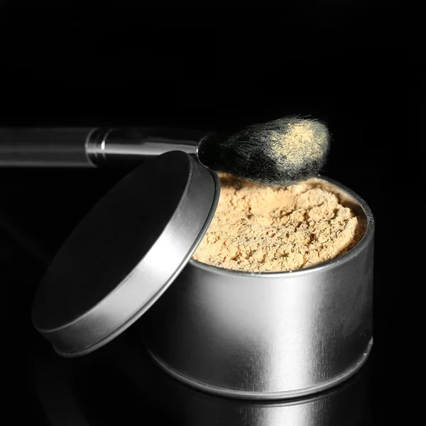 Jar met losse cosmetische poeder en make-up borstel, geïsoleerd op zwart — Stockfoto