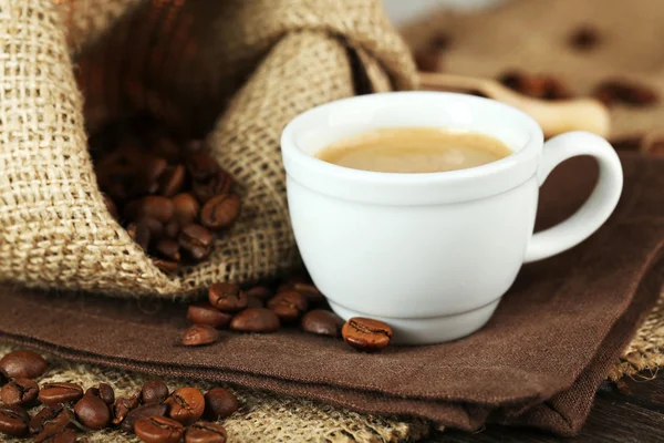 Tazza di caffè con fagioli in tavola da vicino — Foto Stock