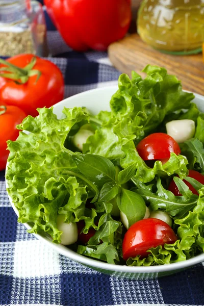 Salada de legumes frescos em tigela na mesa de perto — Fotografia de Stock