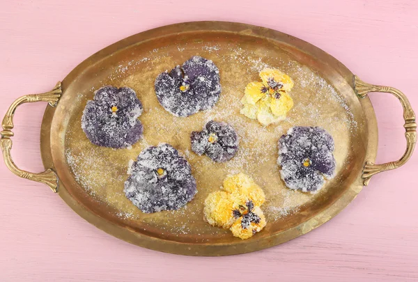 Candied sugared violet flowers on tray, on color wooden background — Stock Photo, Image