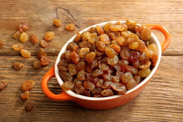 Raisins in pan on wooden table, closeup — Stock Photo, Image