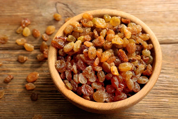 Raisins in bowl on wooden table, closeup — Stock Photo, Image