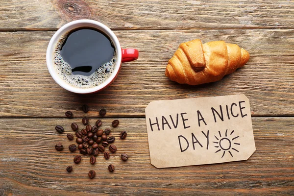 Tazza di caffè e croissant fresco sul tavolo di legno, vista dall'alto — Foto Stock