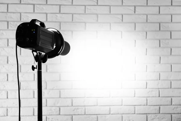 Studio fotografico con attrezzature di illuminazione su sfondo muro di mattoni — Foto Stock