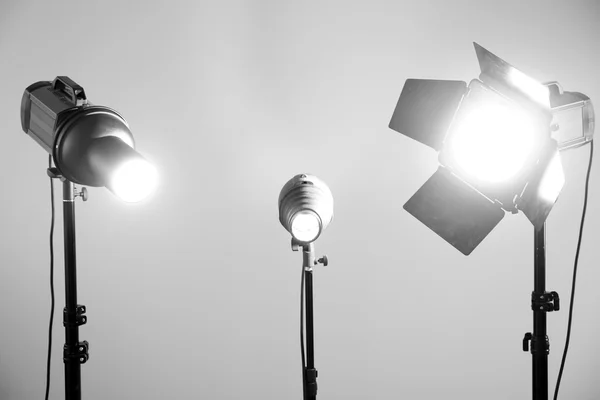 Photo studio with lighting equipment on grey wall background — Stock Photo, Image