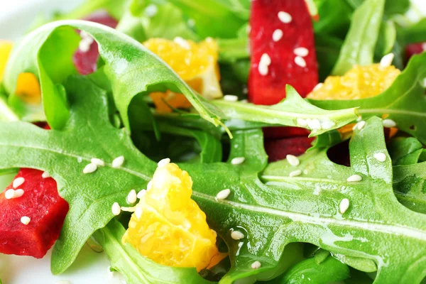 Ensalada sabrosa con hojas de rúcula en plato, primer plano — Foto de Stock