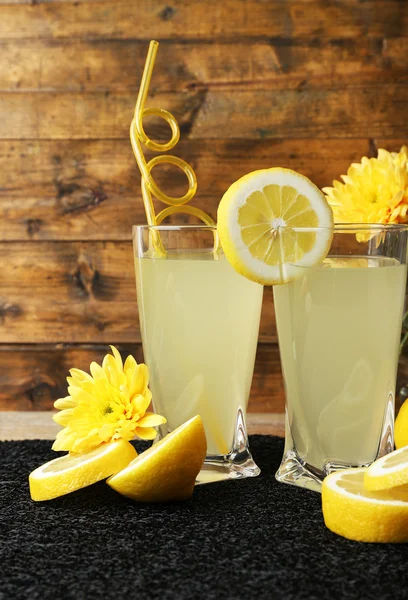 Stillleben mit Zitronensaft und Zitronenscheiben auf Holzgrund — Stockfoto