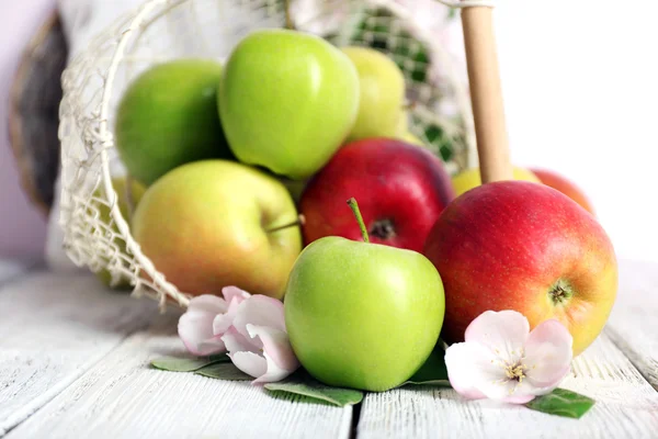 Čerstvá jablka s apple květ na dřevěný stůl — Stock fotografie
