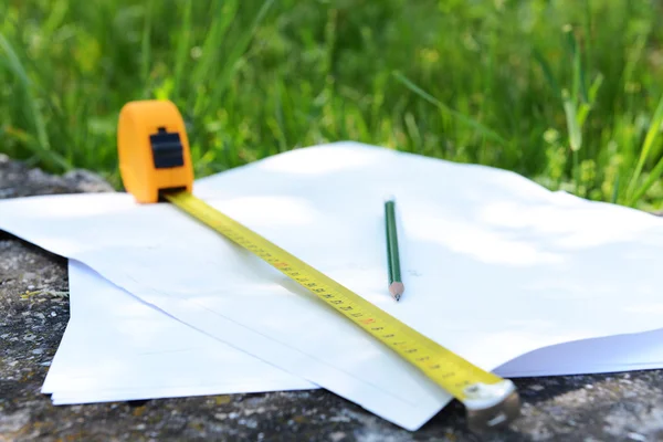 Roleta de construção e lápis em folhas brancas de papel, ao ar livre — Fotografia de Stock