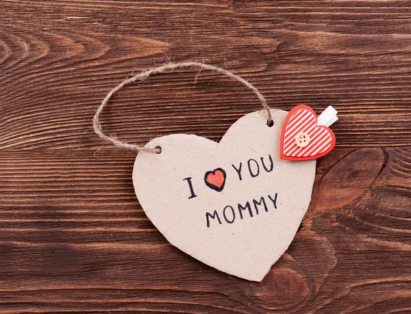 Надпись I LOVE YOU MUMMY on cutout carton on wooden background — стоковое фото