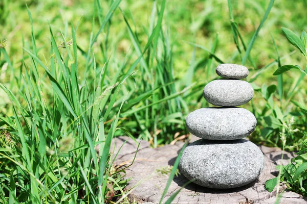 Stack of spa stones over green grass background — Stock Photo, Image