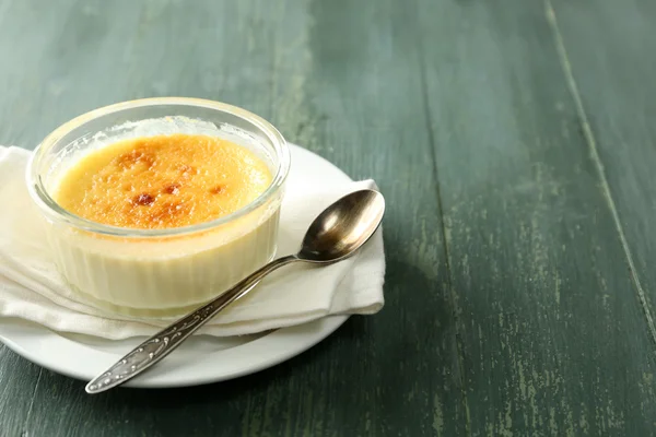 Creme brulee postre en servilleta, sobre fondo de madera de color — Foto de Stock