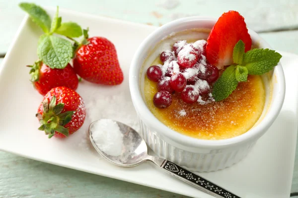 Creme Brulee Dessert mit frischen Erdbeeren auf Serviette, auf farbigem Holzhintergrund — Stockfoto