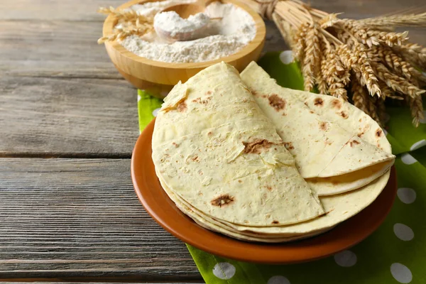 Stapel hausgemachter Vollkornmehl-Tortilla auf Teller, auf Holztischhintergrund — Stockfoto