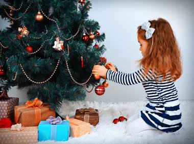 Noel ağacı süsleyen küçük kız