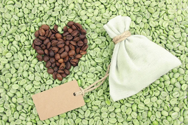 Kahverengi ve yeşil kahve çekirdekleri şeklinde kalp, yakın çekim — Stok fotoğraf