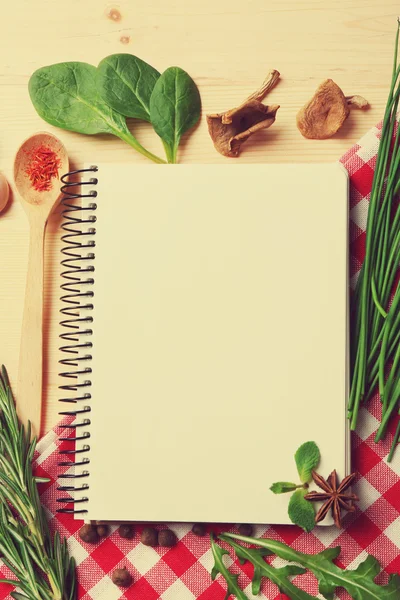 Recipe book page with different herbs on wooden background — Stock Photo, Image