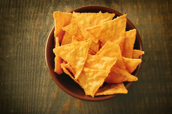 Välsmakande nachos i färg skål, på trä bakgrund — Stockfoto