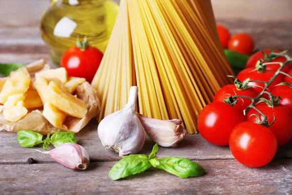Pasta with cherry tomatoes and other ingredients on wooden background — Stock Photo, Image