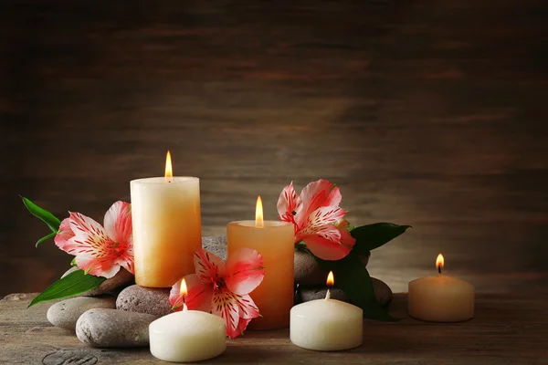 Beautiful composition with candles and spa stones on wooden background — Stock Photo, Image