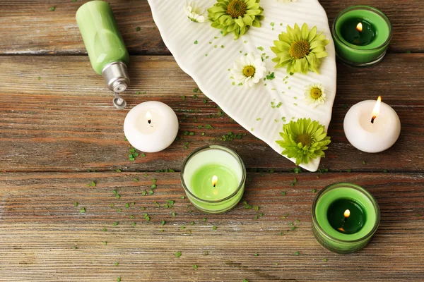Ljus med blommor på tallriken på bordet på nära håll — Stockfoto