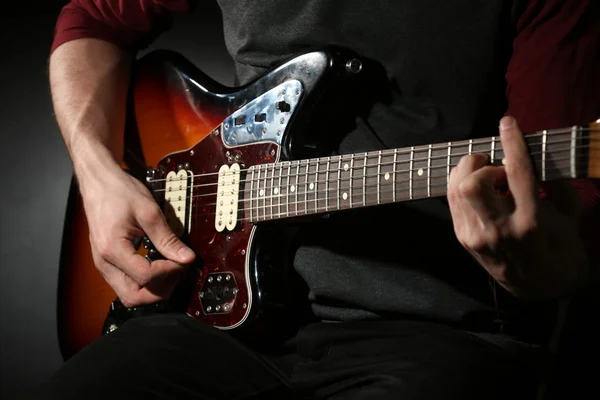 若い男が、暗い背景上のエレキギター演奏 — ストック写真