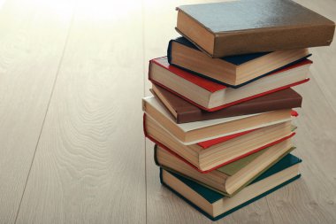 Ahşap zemin üzerine kitap yığını