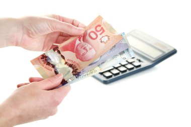 Kanada Doları ve üzerinde beyaz izole hesap makinesi, el