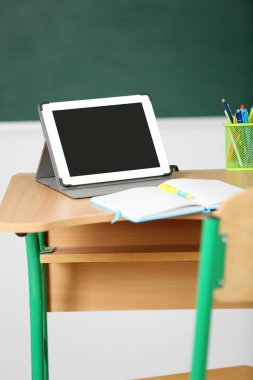 İleti örneği ve yazı tahtası arka plan üzerinde sınıfta tablet ile ahşap masa