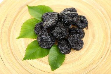 Kuru erik ahşap arka plan üzerinde yapraklarla yığını