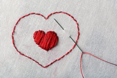 Bezler, nakış ve masada kırmızı dikiş ipliği için yakın çekim