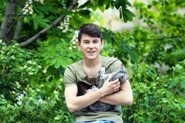 yakışıklı delikanlı ile sevimli kedi açık havada