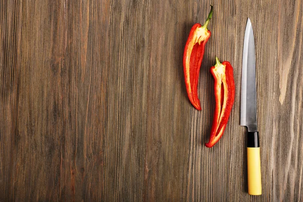 Poloviny pepř chilli s nožem na dřevěné pozadí — Stock fotografie