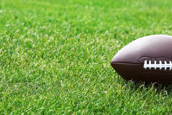 Rugby ball on green field — Stock Photo, Image