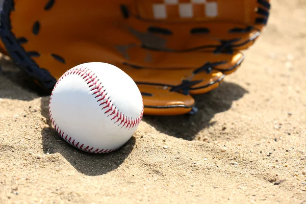 Bola de beisebol e luva na areia — Fotografia de Stock