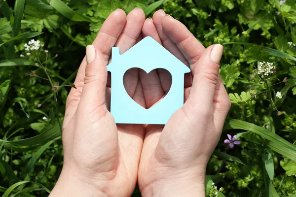 Mani femminili che tengono casa giocattolo all'aperto — Foto Stock