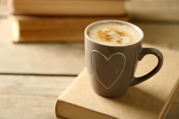 Still life with cup of coffee and books, on wooden table