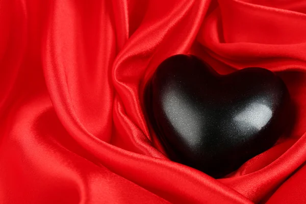 Corazón negro sobre fondo de tela — Foto de Stock