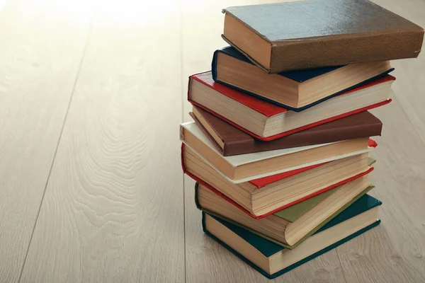 Pila de libros sobre fondo de madera — Foto de Stock