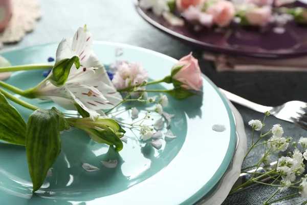 Louça com flores na mesa de perto — Fotografia de Stock